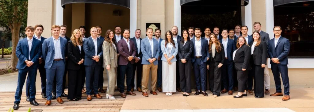 Group of professionals in suits outside.